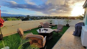 A rooftop terrace with outdoor seating, a grill, and a view of the cityscape. - 5 pools, Amazing Rooftop Views , Beach (Vieques)