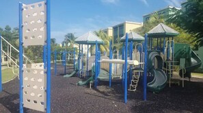 A playground with climbing structures, slides, and a covered area.
