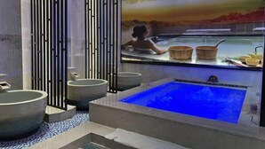 A modern spa with a large blue hot tub, a wooden bath, and a serene mural of a woman in a hot tub. - Huarong Hongfa International Hotel (People's Square) (Huarong)