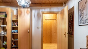 A wooden interior with a door, shelves, and a patterned wall.