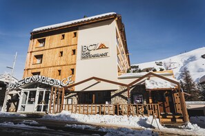 Ein mehrstöckiges Holzgebäude mit einem Schild für "BC7 Bar Restaurant" und "BASE CAMPLODGE".