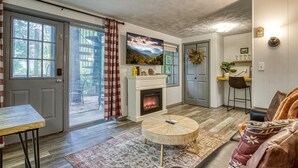 Ein gemütliches Wohnzimmer mit Kamin, Essbereich und Blick ins Freie.