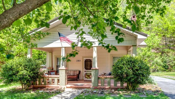 A single-story house with a porch, a mailbox, and a small garden.