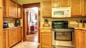 A kitchen with wooden cabinets, a stainless steel stove, and a microwave.