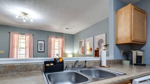 A kitchen with two sinks, a coffee maker, and wooden cabinets.