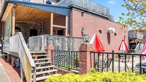 A brick building with a wooden deck and outdoor seating area.