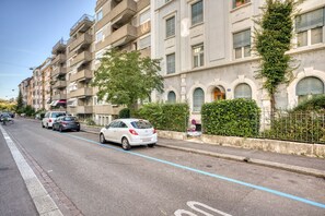 A multi-story residential building with balconies, a tree-lined street, and parked cars. - Charming Breite 3 Room w/ Washer & Storage, nr Market, by Blueground (Basel)