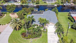 Una propiedad residencial con una casa grande, piscina y muelle.