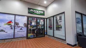 Un magasin de ski avec une enseigne indiquant « Black Dog Sports », une publicité pour la marque Dynastar et une vitrine fermée.