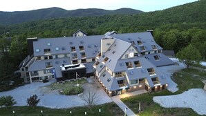 Un hotel de varios pisos con un diseño arquitectónico moderno, que cuenta con balcones y un patio central.