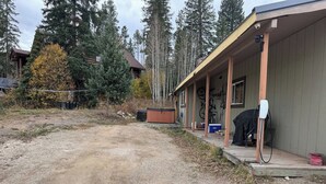 A building with a porch, a hot tub, and a covered outdoor area.