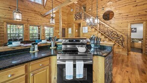 Une cuisine spacieuse dotée d’un grand îlot central, d’appareils électroménagers en acier inoxydable et d’un intérieur en bois.