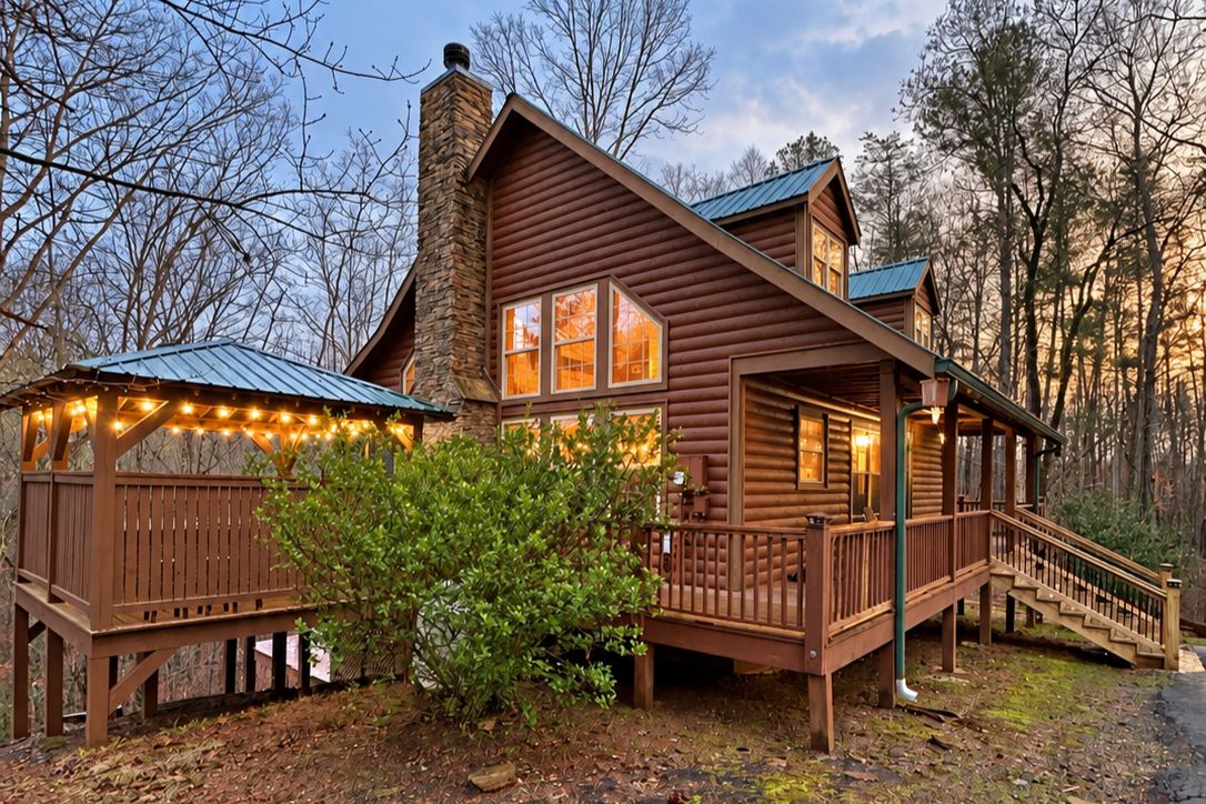 A log cabin with a porch and a staircase leading to the entrance.