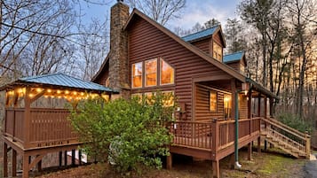 A log cabin with a porch and a staircase leading to the entrance.