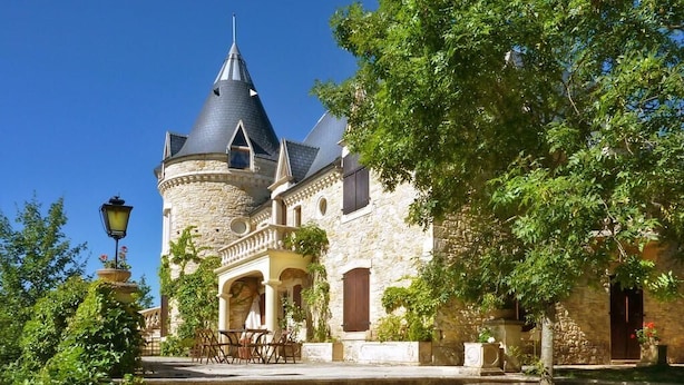 A historic stone building with a turret and a staircase leading to the entrance.