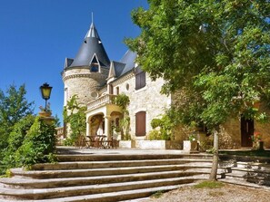 Un edificio histórico de piedra con una torre y una escalera que conduce a la entrada.