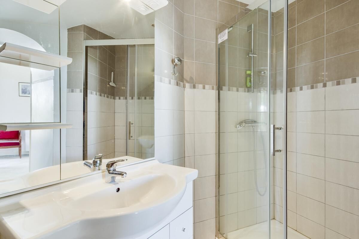 Een bad/douchecombinatie, handdoeken, toiletpapier