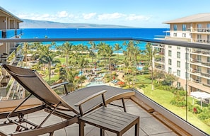 Un balcon avec des chaises longues donnant sur une piscine de complexe hôtelier et offrant une vue sur l’océan.