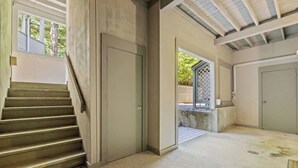 A staircase leading to a door, a concrete floor, and a view of a garden area. - Samoset Lakeview Gem - Vibrant Condo Escape! (Gilford)