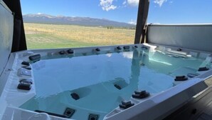Un jacuzzi con vistas despejadas a las montañas al fondo.