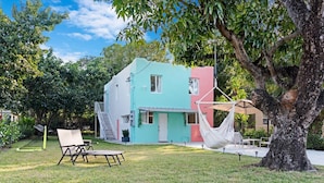 A two-story house with a hammock and outdoor seating. - Wynwood Apartments (Miami)