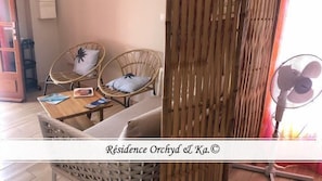 Relax in a traditional room with a wooden table, wicker chair, and a bamboo screen.