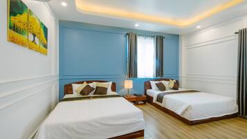 A hotel room with two beds, a nightstand with a lamp, and a painting on the wall.