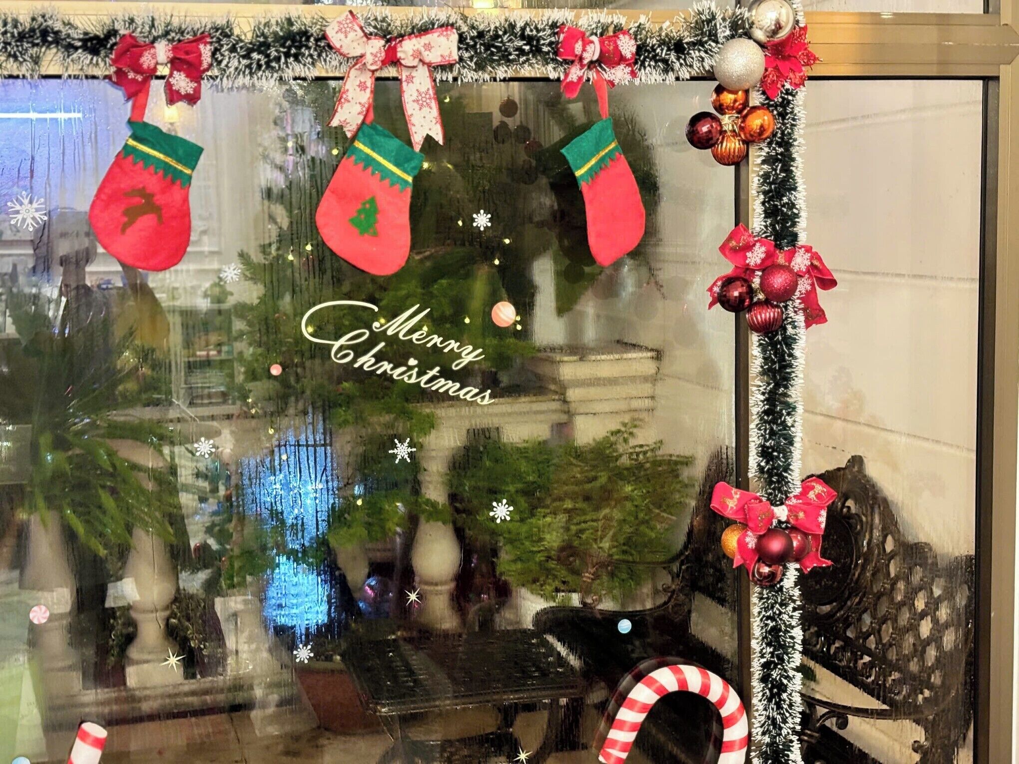 A decorated window with Christmas stockings, a 'Merry Christmas' sign, and festive ornaments.
