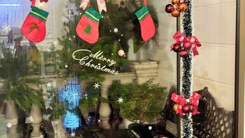 A decorated window with Christmas stockings, a 'Merry Christmas' sign, and festive ornaments.