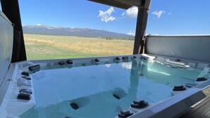 Un jacuzzi con vistas despejadas a un paisaje montañoso.