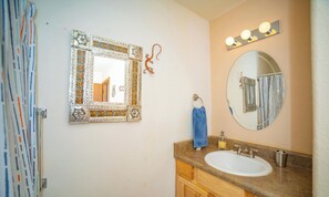 A bathroom with a sink, mirror, and towel rack.
