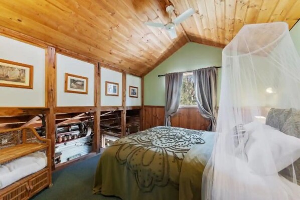 A cozy room with a bed, wooden shelves, and a ceiling fan. - Quirky Barn, Close to Melbourne. (Avenel)