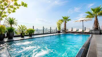 Una piscina al aire libre, tumbonas