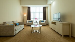 A hotel room with two sofas, a coffee table, a TV on a stand, and a floor lamp. - Zecon Hotel (Kuala Lumpur)