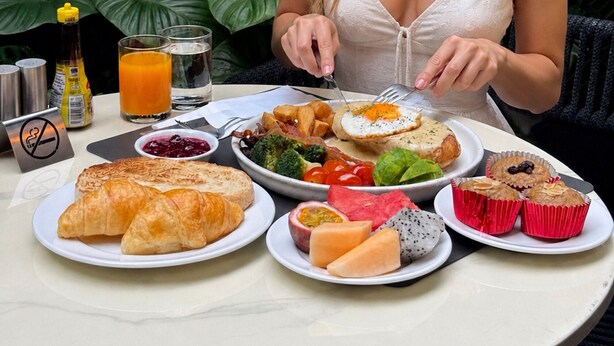 A dining table with plates of food, a bottle of juice, and a glass of water. - Passa Hotel Bangkok (Bangkok)