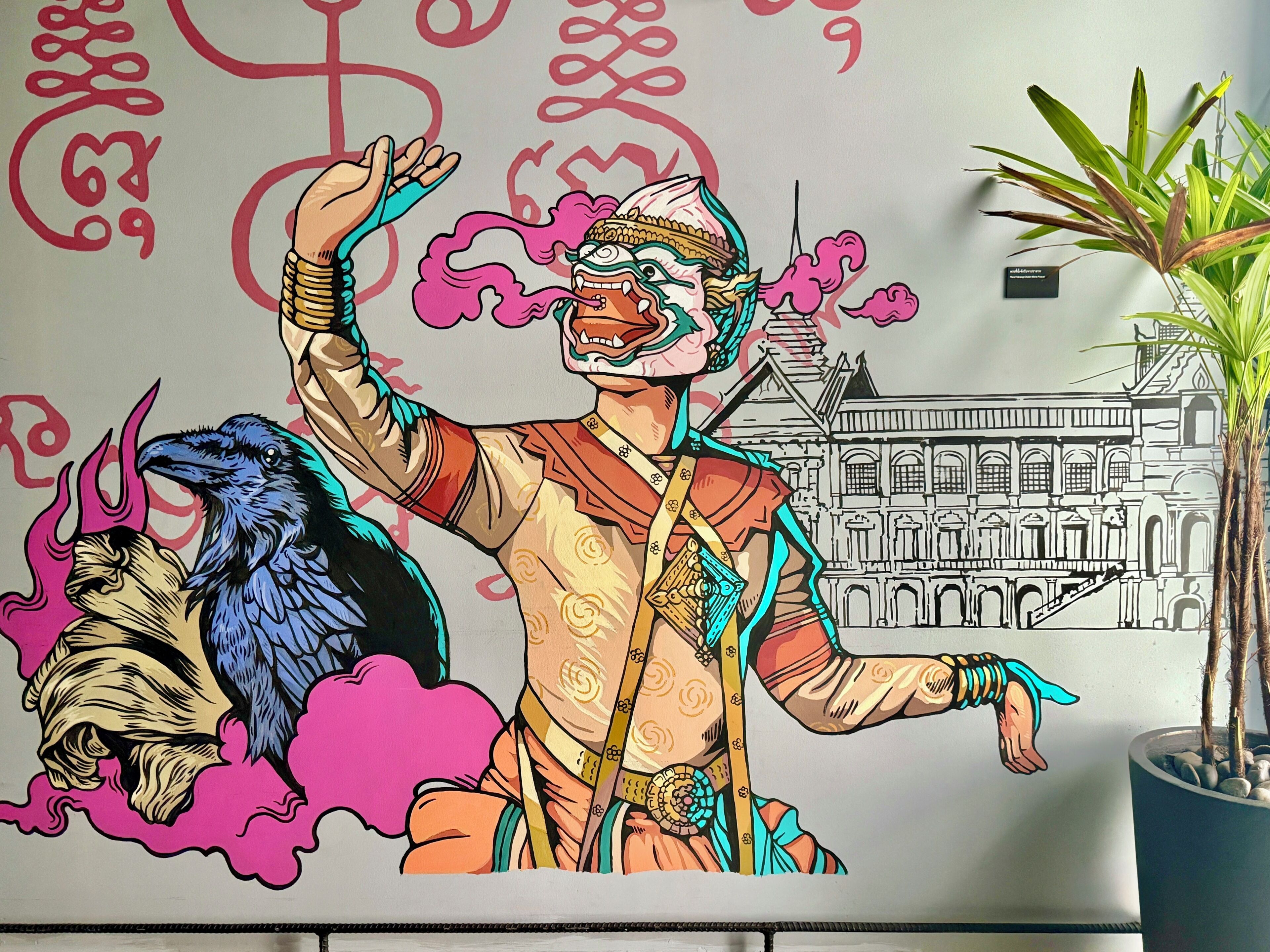 A mural with a person and a bird, a building outline, and a potted plant.