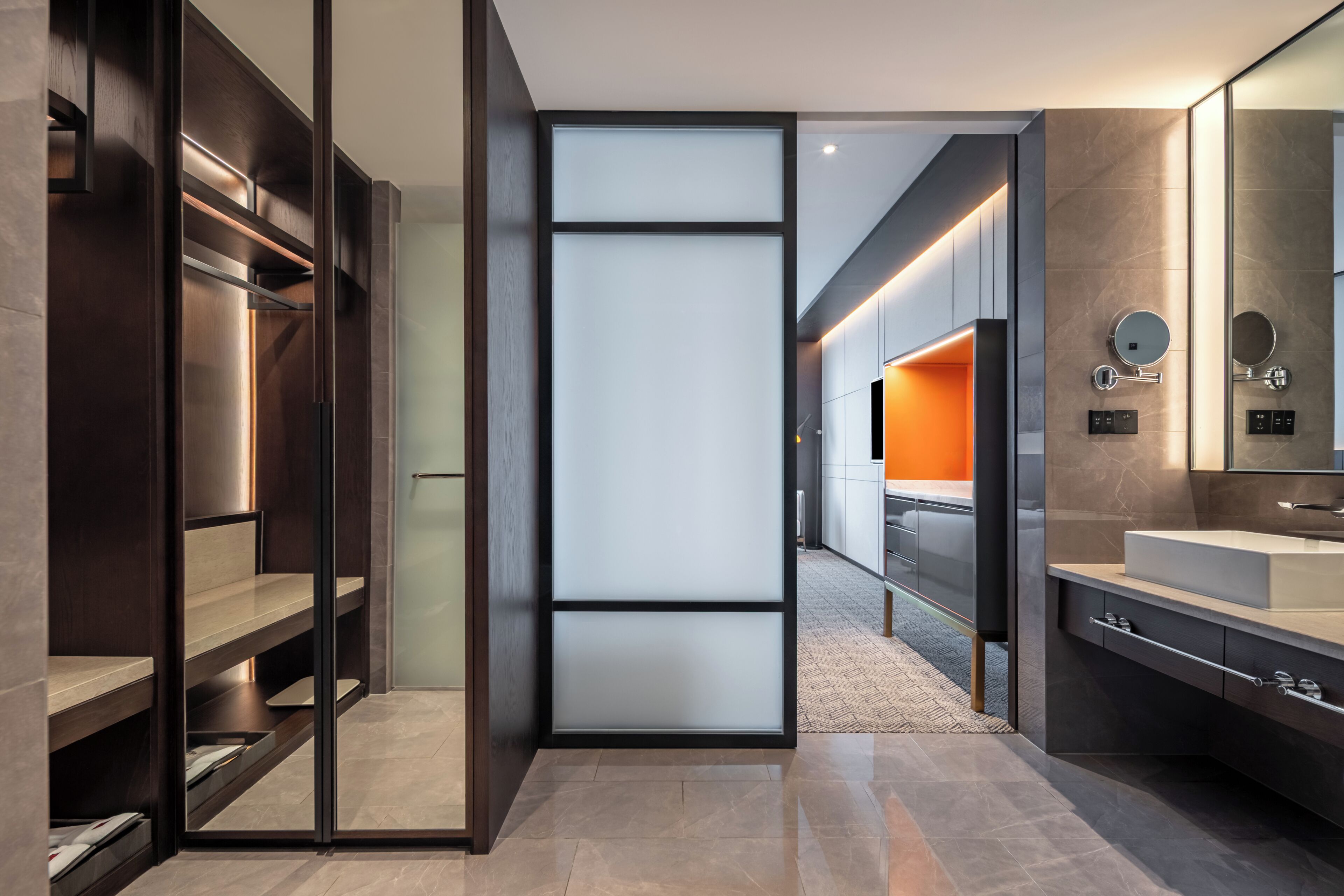 A modern bathroom with a large mirror, a sink, and a walk-in shower.