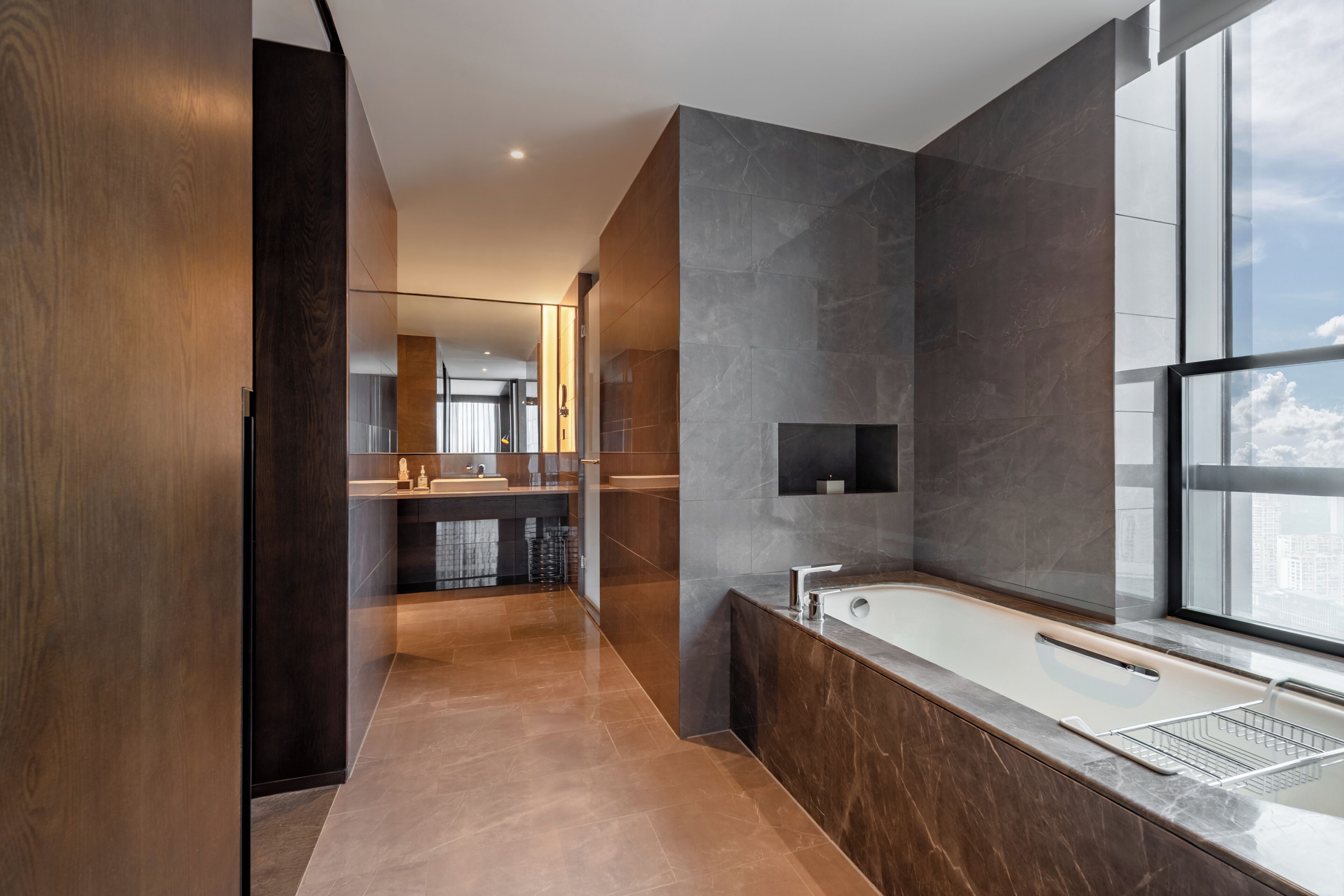 Une salle de bain moderne avec une grande baignoire, un miroir et une fenêtre.