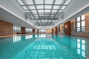 A large indoor swimming pool with a skylight ceiling, wooden panel walls, and large windows. - Grand New Century Hotel, Wenzhou, A Tribute Portfolio Hotel (Wenzhou)