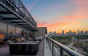A rooftop terrace with outdoor seating, a city skyline view, and a modern architectural design. - Grand New Century Hotel, Wenzhou, A Tribute Portfolio Hotel (Wenzhou)