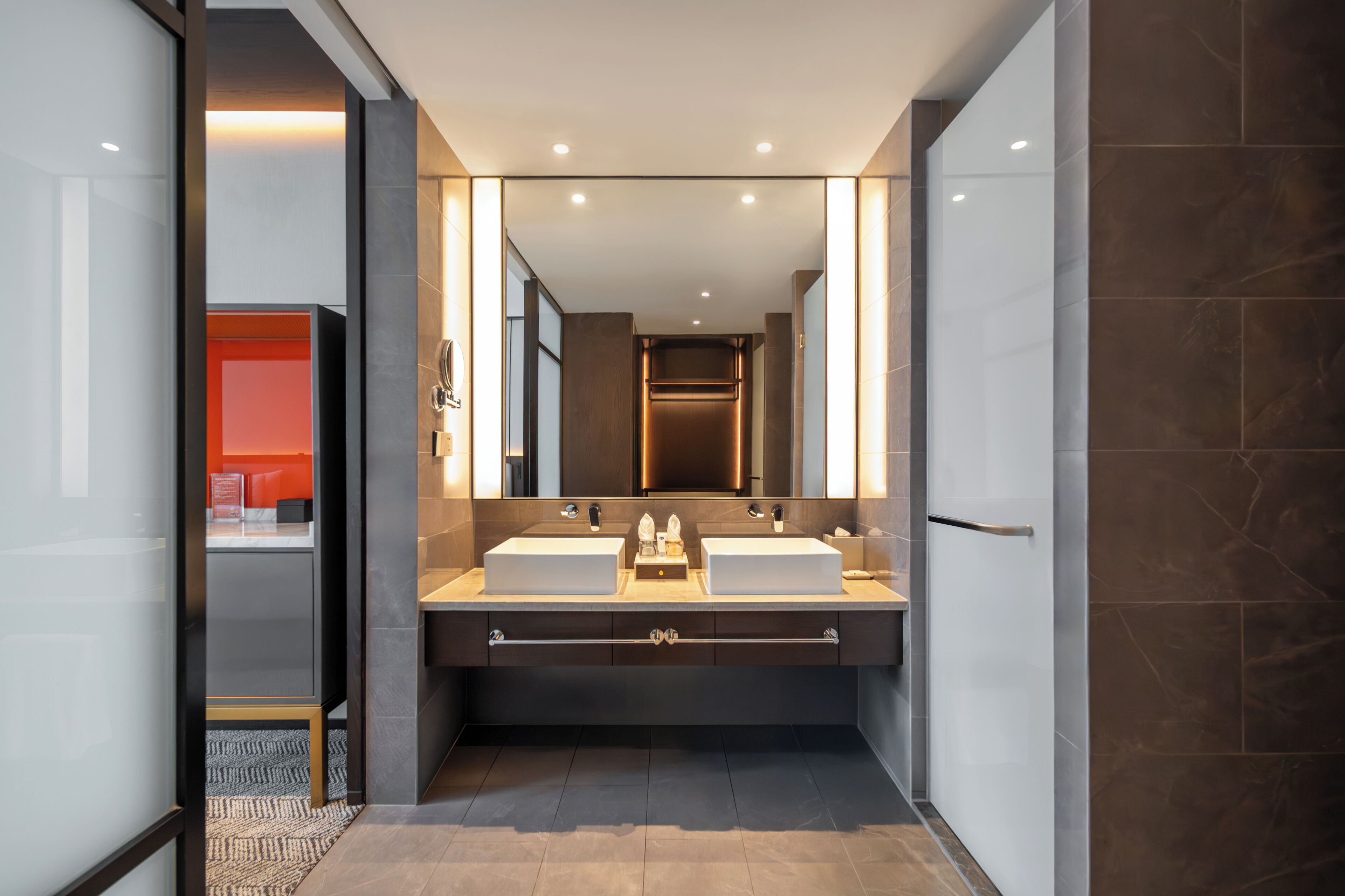 Un baño moderno con lavamanos dobles, un espejo grande y un diseño elegante.