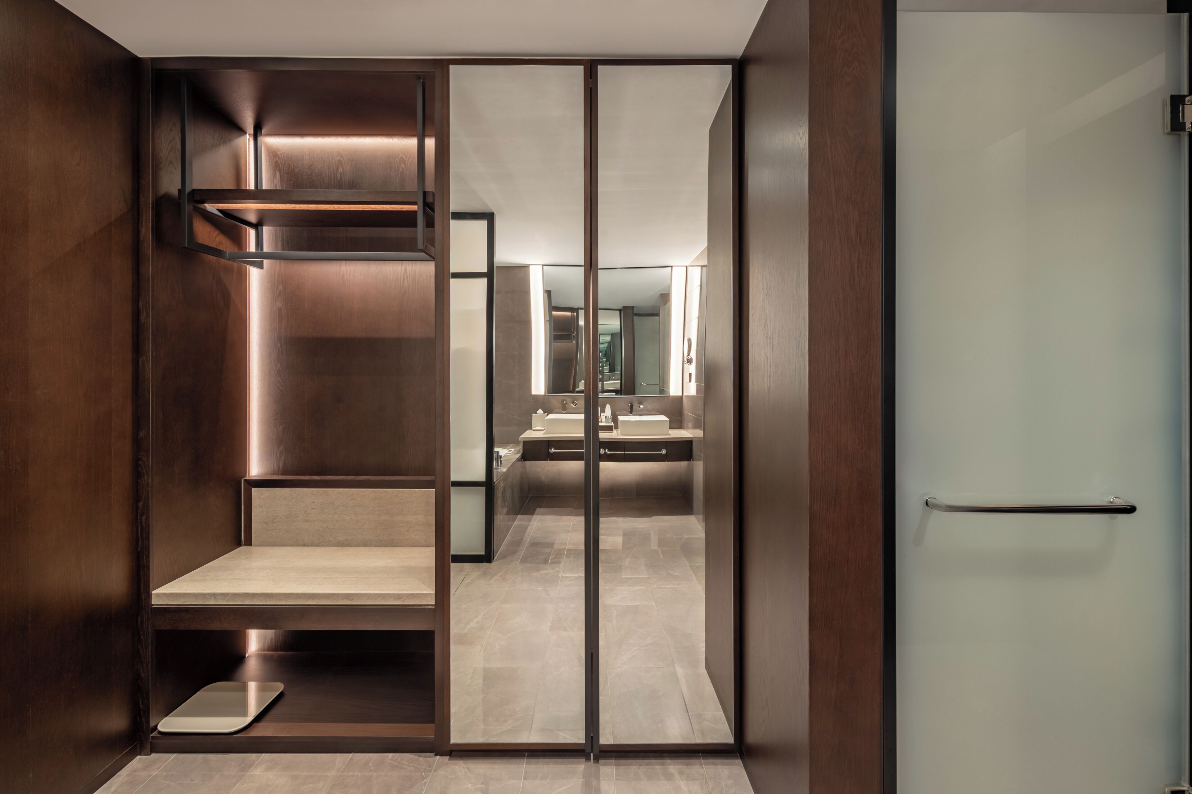 Un baño moderno con espejo, dos lavamanos y zona de ducha.