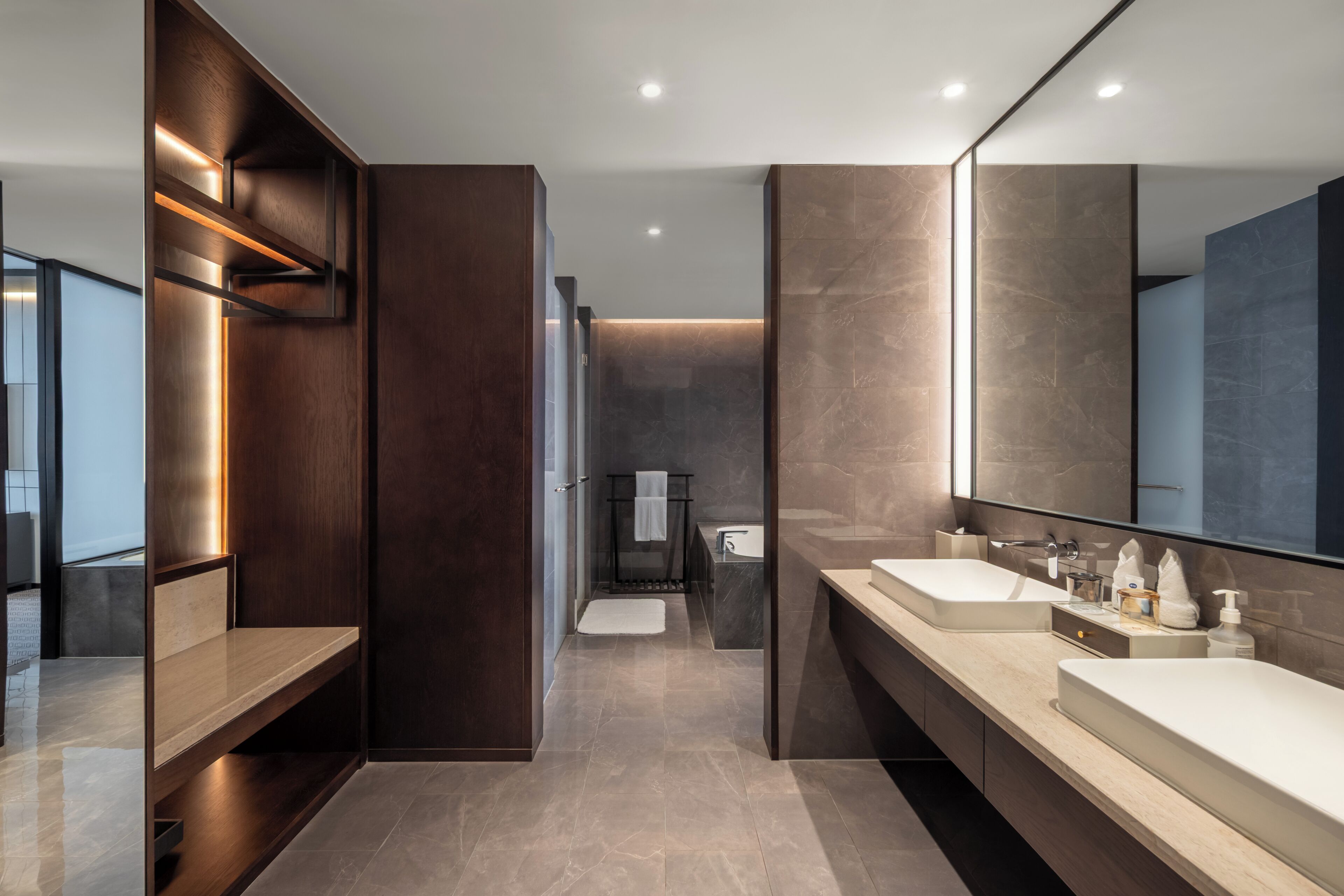 Une salle de bain moderne avec deux lavabos, un grand miroir et une douche à l’italienne.
