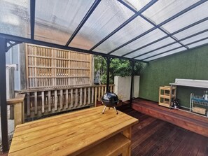 Enjoy dining and socializing in this outdoor patio area with a barbecue grill and sheltered seating.