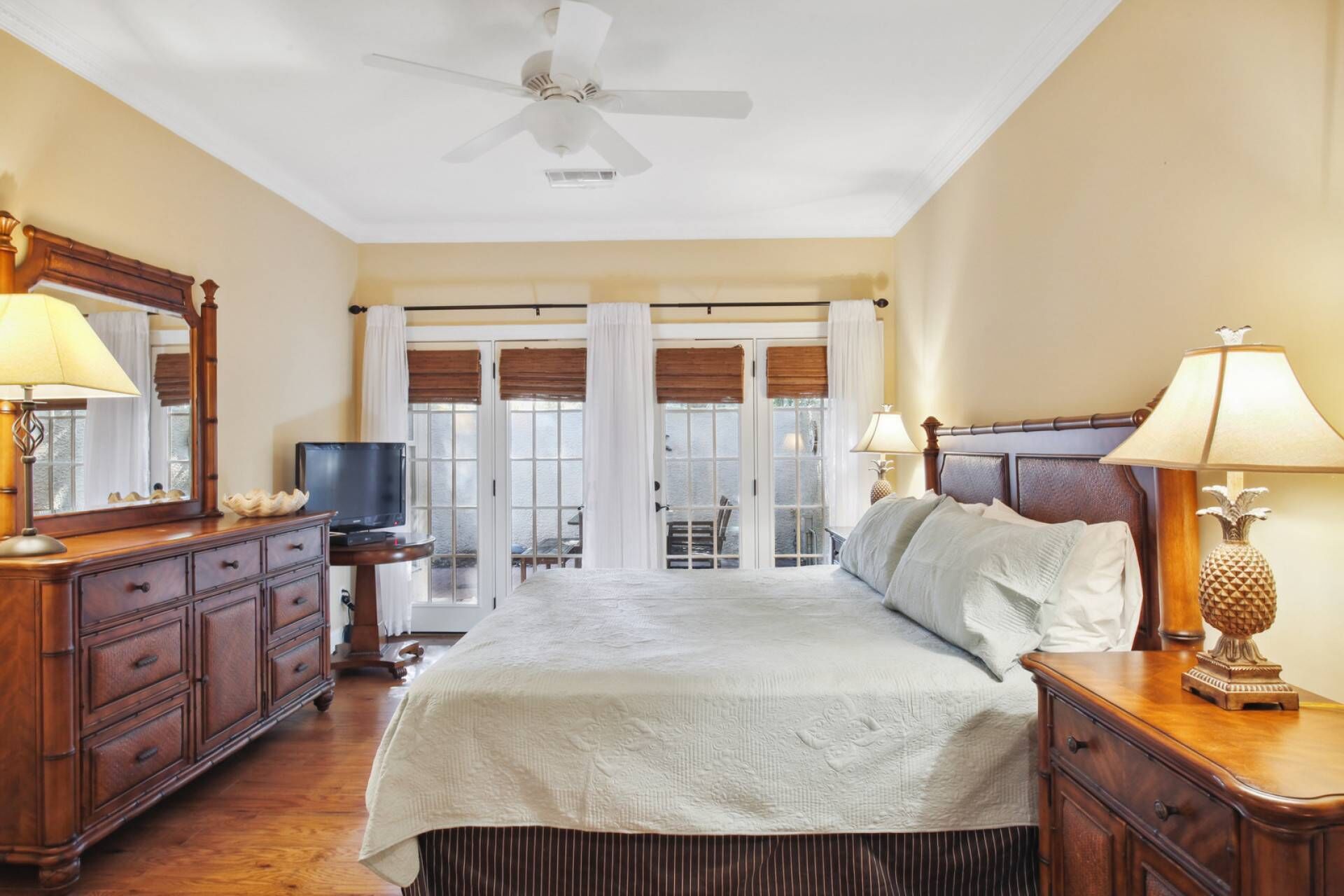 A hotel room with a bed, a television, a desk, and a view of the outside.