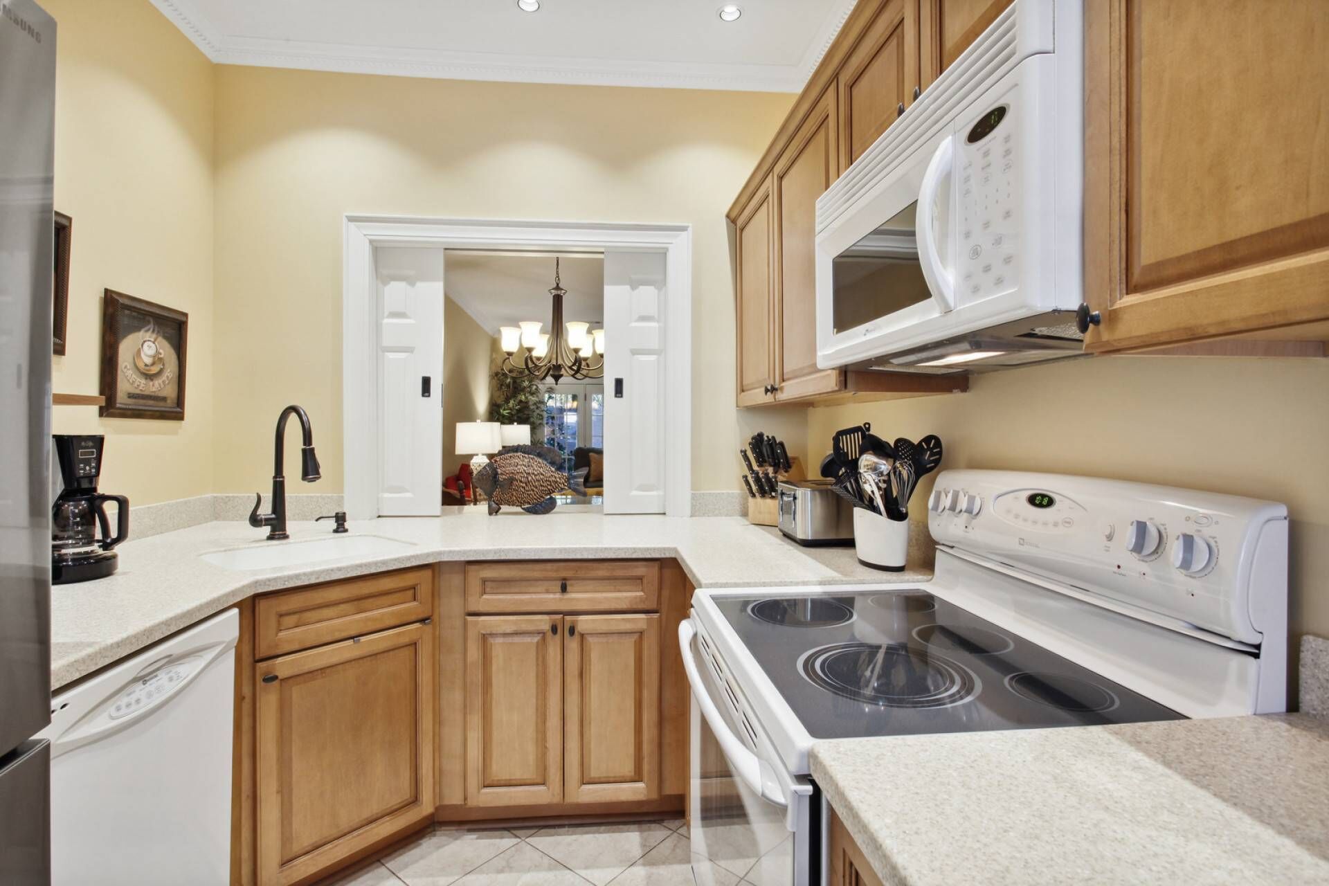 A kitchen with wooden cabinets, a white stove, a microwave, and a coffee maker.