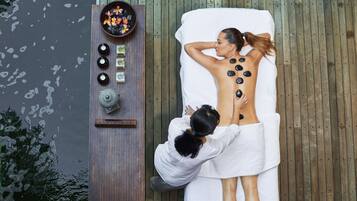 Relax with a rejuvenating hot stone massage on our spa table, surrounded by soothing ambiance.