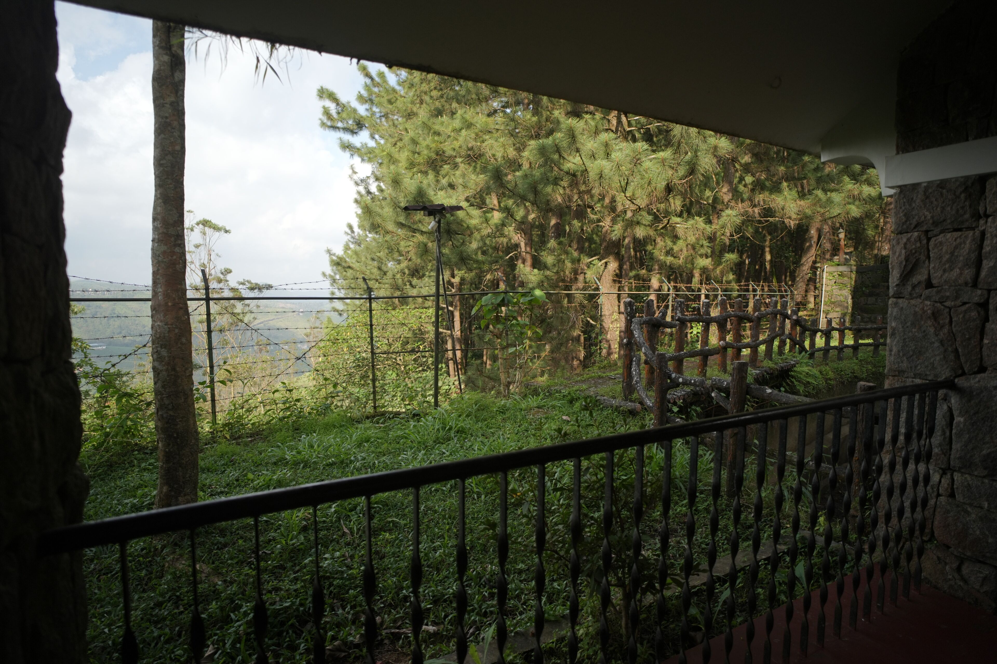 A balcony with a view of a forested area and a body of water.
