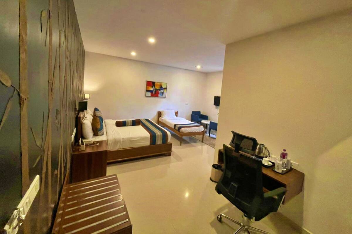 Una habitación de hotel con cama, escritorio, silla y televisor.