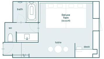 Un plan d’étage comprenant une chambre double de luxe (32,64 m²), une salle de bain, des toilettes, une table et un bureau.